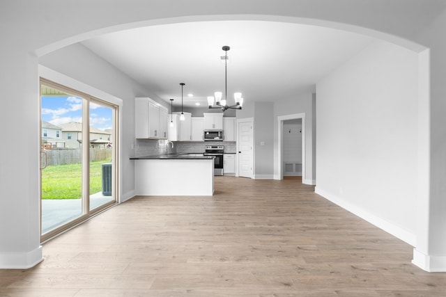 kitchen featuring white cabinetry, tasteful backsplash, a chandelier, hanging light fixtures, and appliances with stainless steel finishes