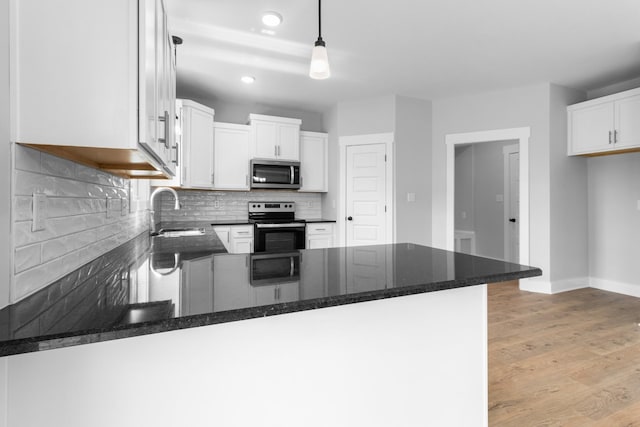 kitchen featuring sink, electric range, decorative light fixtures, and white cabinets