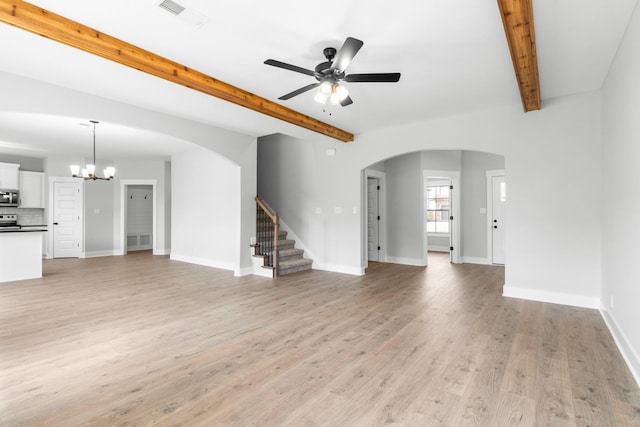 unfurnished living room featuring beam ceiling, ceiling fan with notable chandelier, and light wood-type flooring