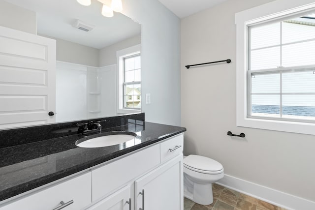 bathroom with vanity, a wealth of natural light, and toilet