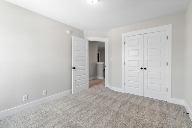 unfurnished bedroom featuring light carpet and a closet