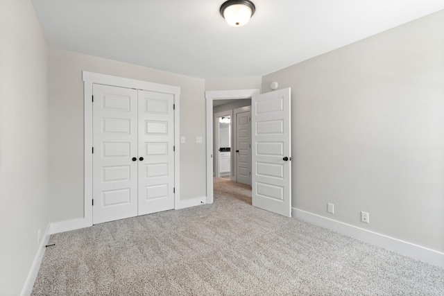 unfurnished bedroom featuring light colored carpet and a closet