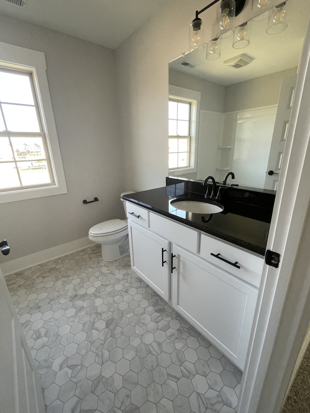 bathroom with vanity, a shower, and toilet