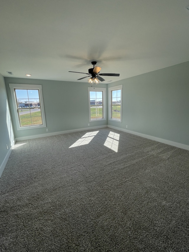 carpeted spare room with plenty of natural light and ceiling fan