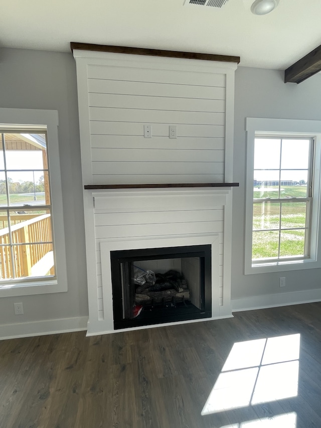 details featuring a large fireplace, wood-type flooring, and beam ceiling