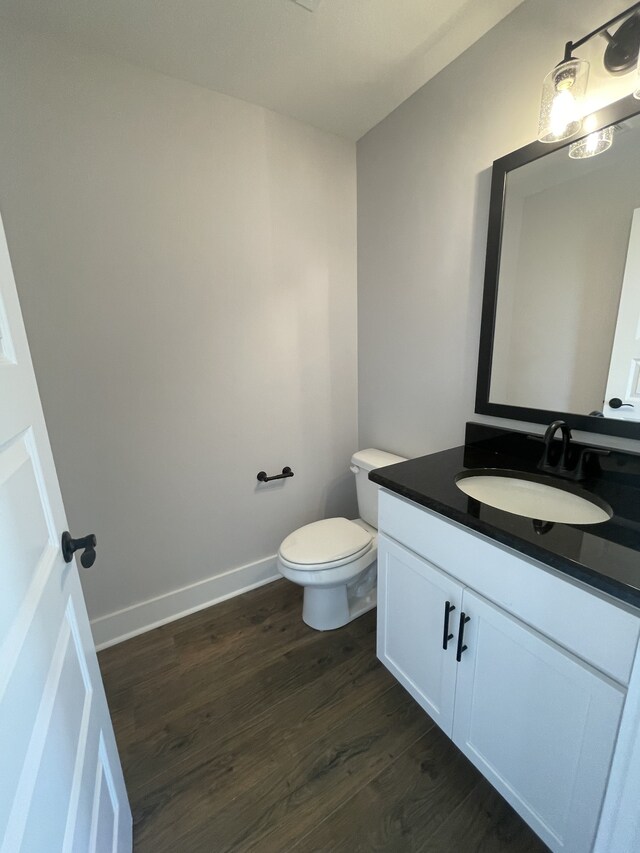 bathroom with vanity, toilet, and hardwood / wood-style floors