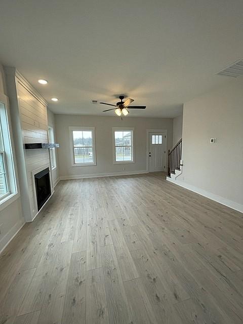 unfurnished living room featuring ceiling fan, light hardwood / wood-style flooring, and plenty of natural light