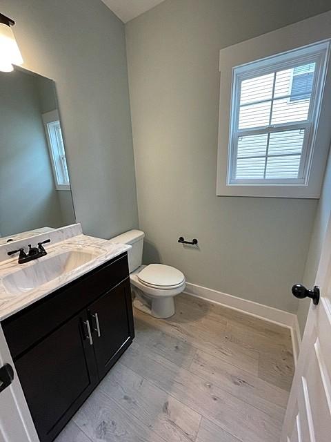 bathroom with vanity, hardwood / wood-style floors, and toilet