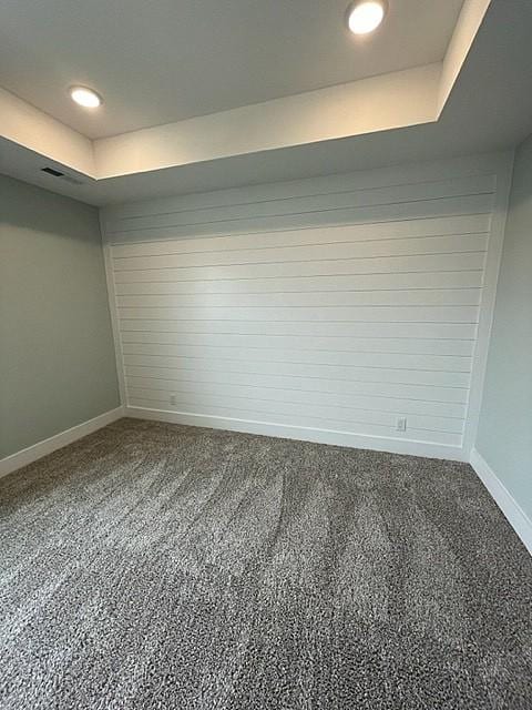 unfurnished room with carpet flooring and a tray ceiling