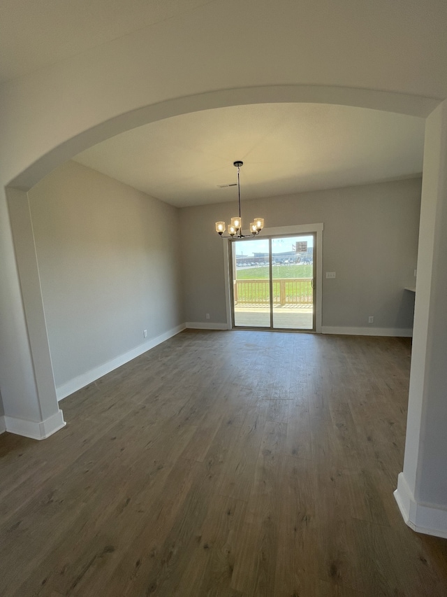 unfurnished dining area with dark hardwood / wood-style flooring and a chandelier