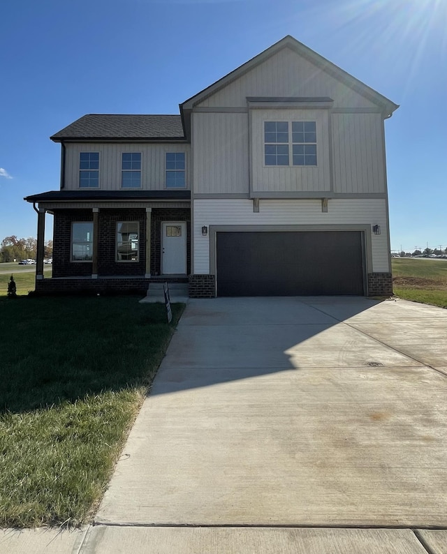 view of front of home with a garage, a front yard, and covered porch