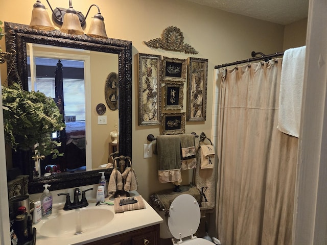 bathroom with vanity, toilet, a shower with shower curtain, and a textured ceiling