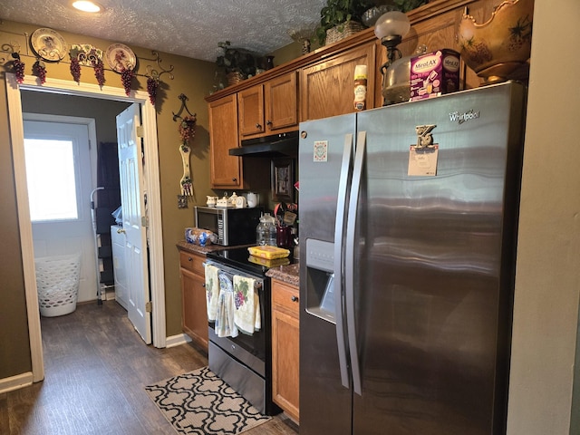 kitchen featuring appliances with stainless steel finishes, dark hardwood / wood-style flooring, and a textured ceiling