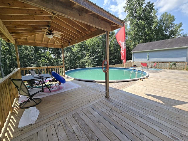 view of swimming pool featuring a wooden deck and ceiling fan