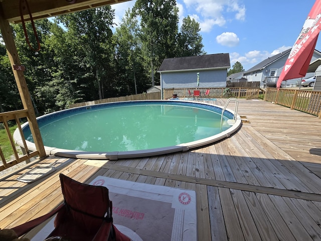 view of swimming pool with a fenced backyard, a deck, and a fenced in pool