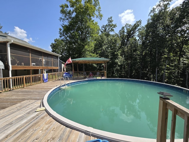 outdoor pool featuring a sunroom and a deck