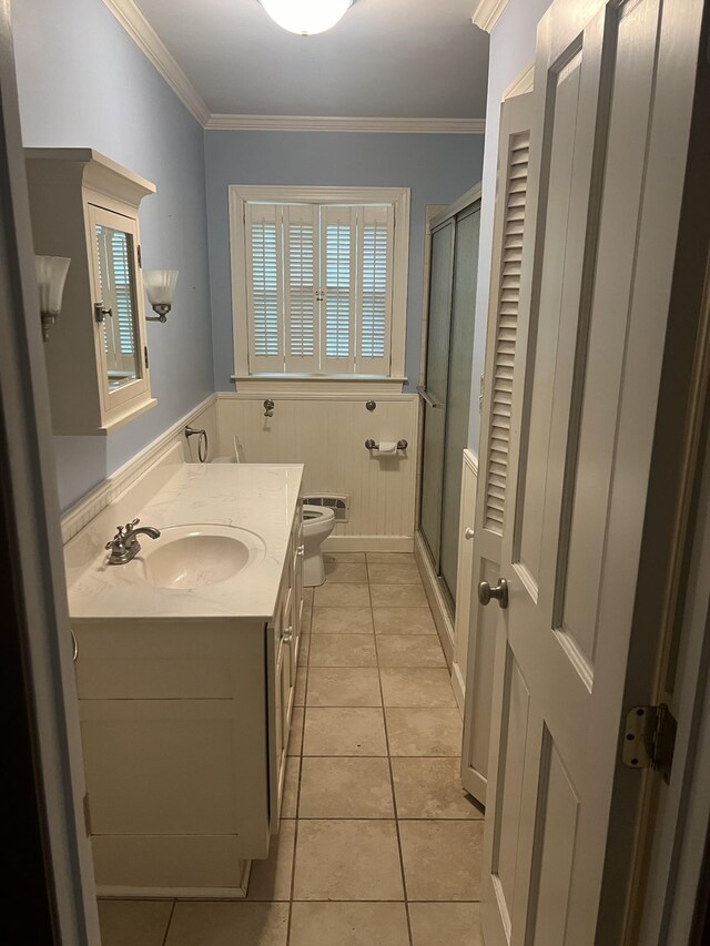 bathroom with tile patterned floors, vanity, an enclosed shower, and ornamental molding