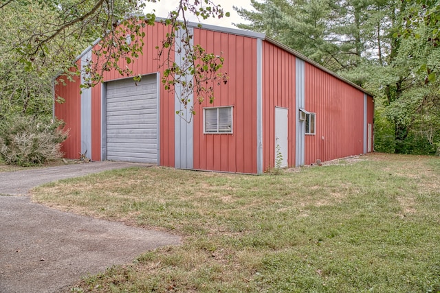 view of outdoor structure featuring a lawn and a garage