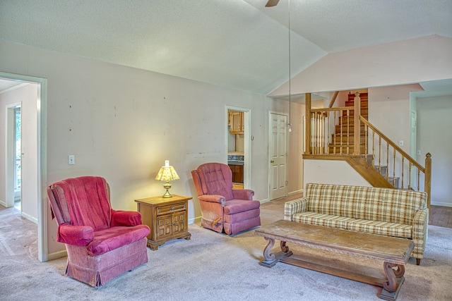 living area with lofted ceiling, a textured ceiling, and carpet flooring