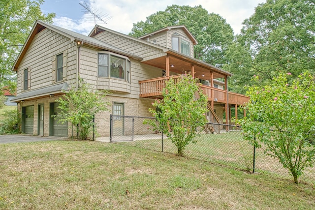 rear view of house featuring a wooden deck, a garage, and a lawn