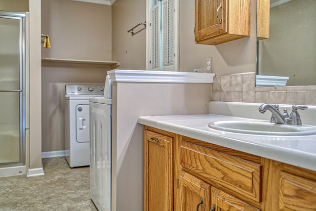 bathroom with vanity, independent washer and dryer, and an enclosed shower