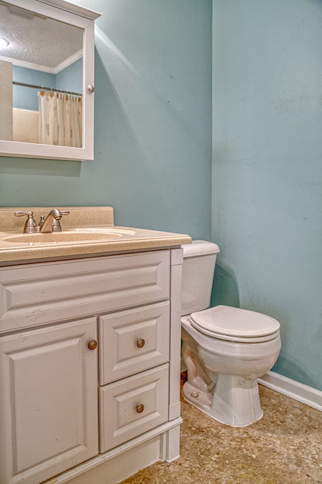 bathroom with vanity, toilet, and a textured ceiling