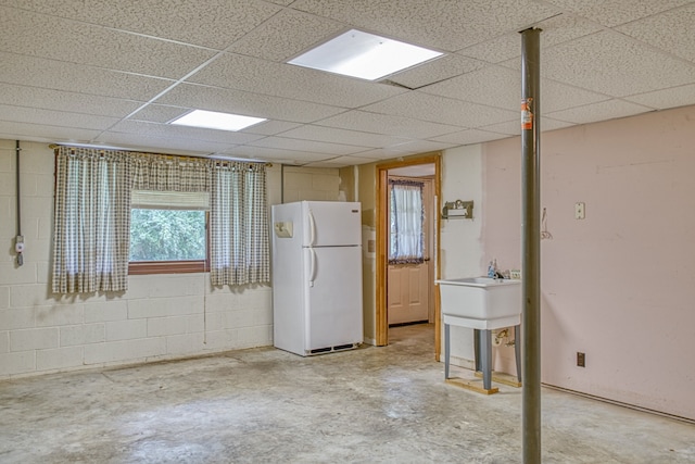 spare room featuring a drop ceiling, concrete flooring, and sink