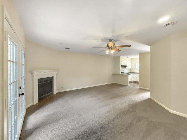 unfurnished living room with ceiling fan and carpet flooring