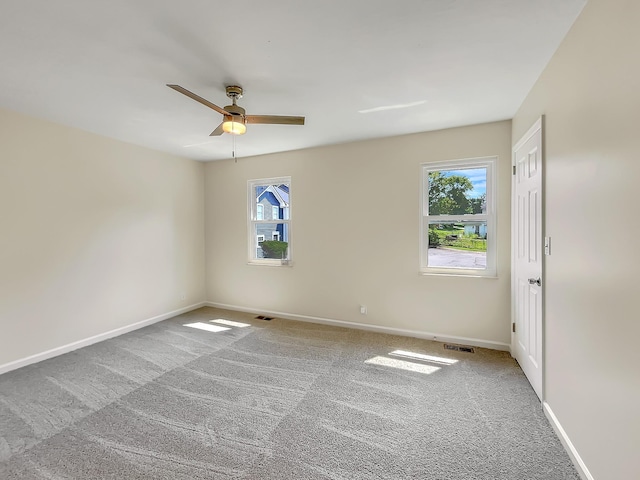 spare room featuring a wealth of natural light, ceiling fan, and carpet flooring