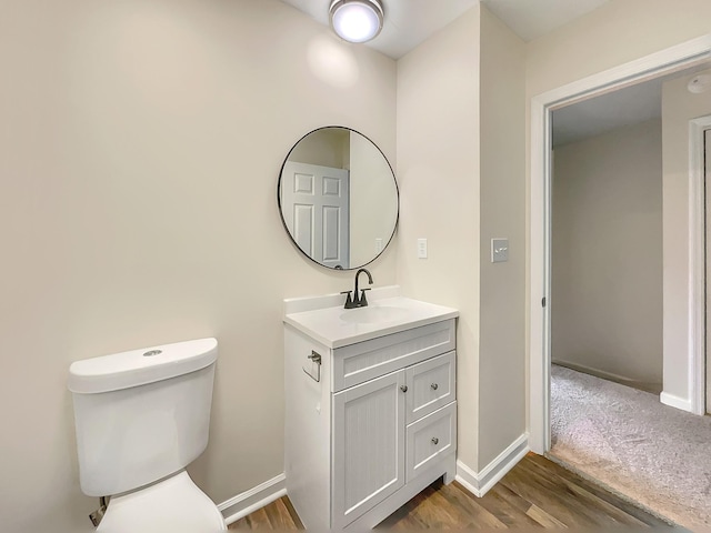 bathroom featuring vanity, hardwood / wood-style flooring, and toilet