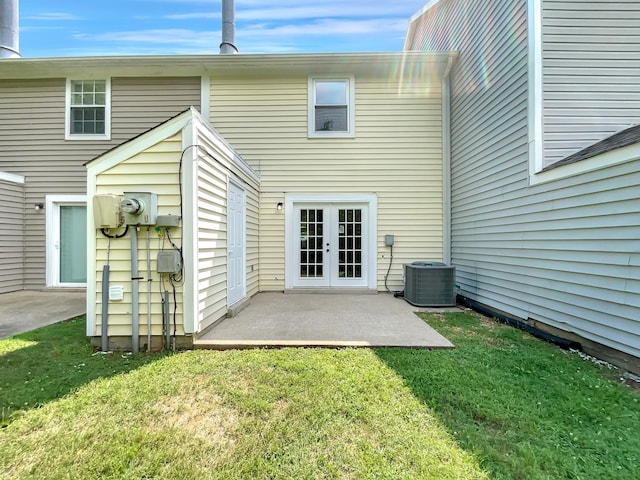 rear view of property featuring central AC unit, a yard, a patio area, and french doors