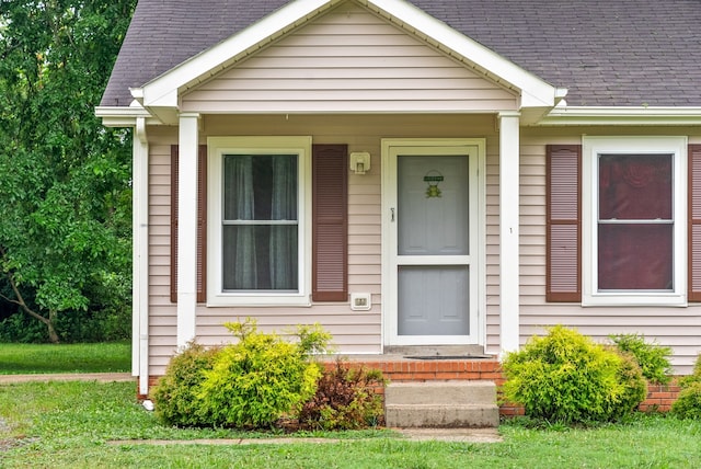 view of exterior entry with a yard