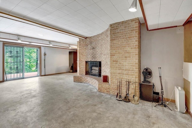 unfurnished living room featuring brick wall, concrete flooring, and a brick fireplace