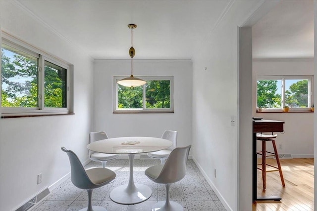 dining area featuring light hardwood / wood-style floors and crown molding