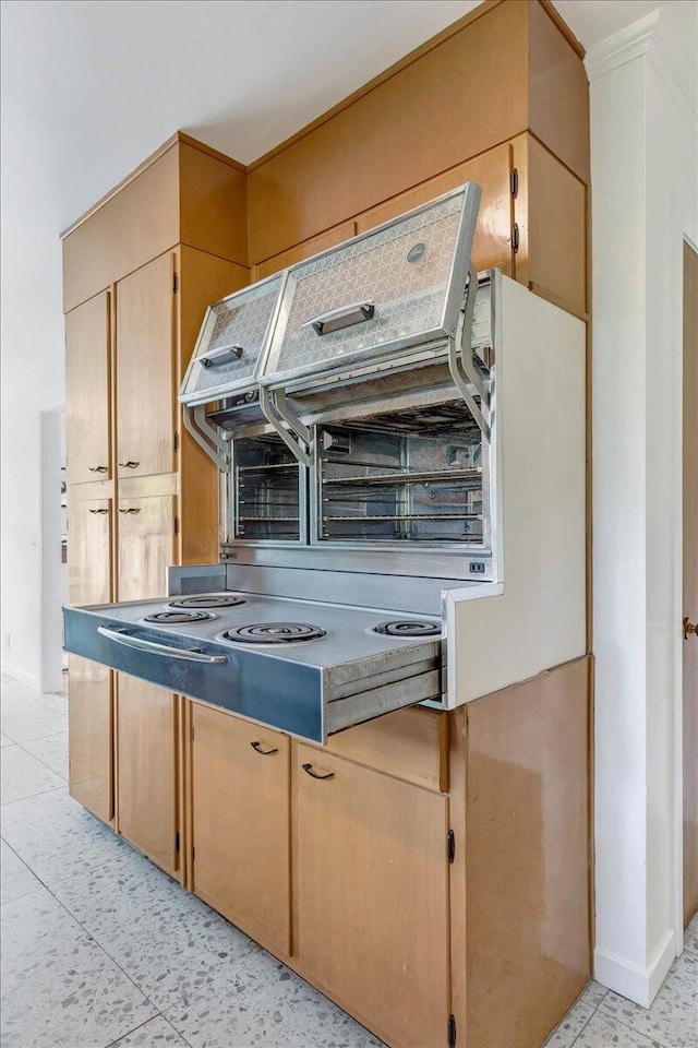 kitchen featuring light brown cabinetry, ornamental molding, and light tile patterned floors