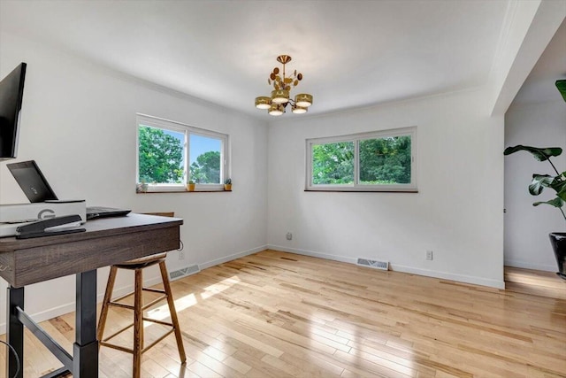 office space featuring light hardwood / wood-style flooring, a notable chandelier, and ornamental molding