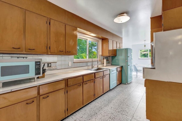 kitchen with light tile patterned floors, dishwasher, backsplash, fridge, and sink