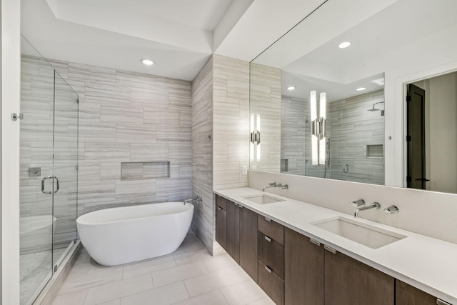 bathroom with tile walls, vanity, tile patterned floors, and plus walk in shower