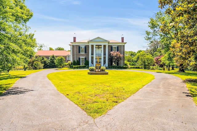 neoclassical home featuring a front yard