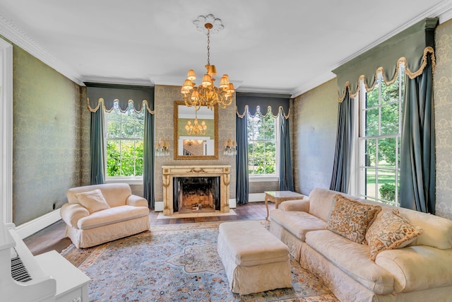 living room with a chandelier, hardwood / wood-style flooring, a large fireplace, and a healthy amount of sunlight