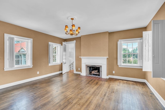 unfurnished living room featuring wood-type flooring and a notable chandelier