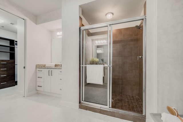 bathroom featuring vanity and a shower with door