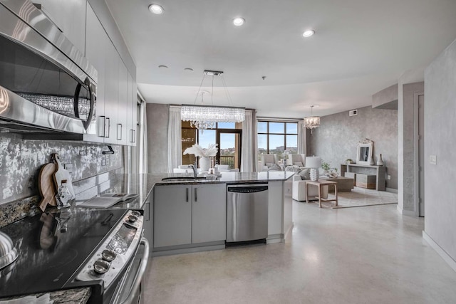 kitchen with sink, gray cabinets, stainless steel appliances, a notable chandelier, and decorative light fixtures