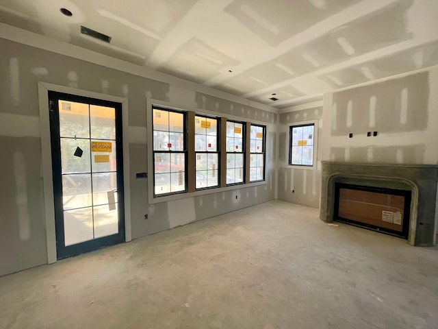 unfurnished living room with a fireplace and concrete flooring