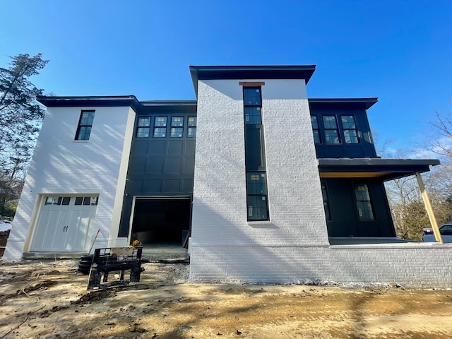 rear view of property featuring a garage