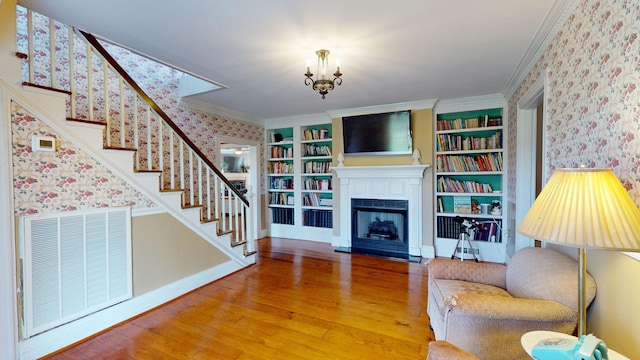 unfurnished living room with an inviting chandelier, ornamental molding, and wood-type flooring