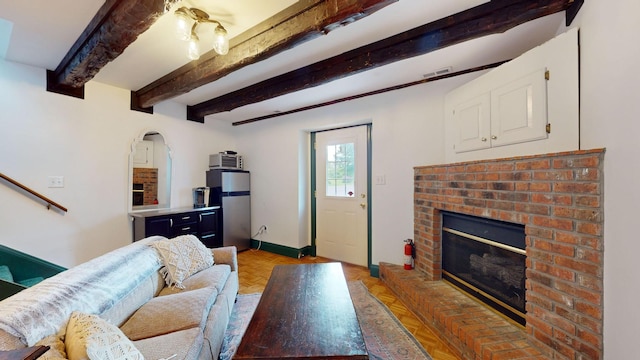 living room with light parquet flooring, a fireplace, and beam ceiling