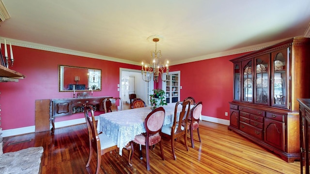 dining space with ornamental molding, a chandelier, and light hardwood / wood-style floors