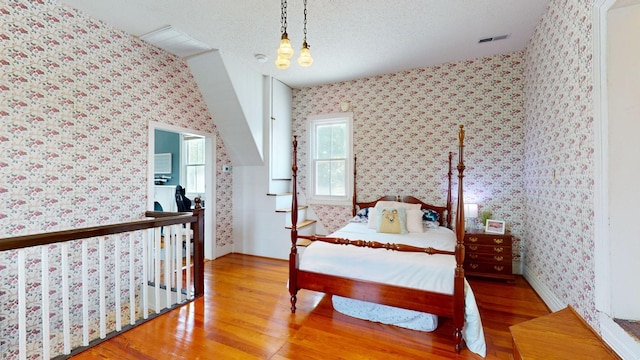 bedroom with hardwood / wood-style flooring and a textured ceiling