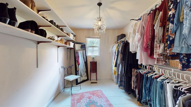 spacious closet with a chandelier and light tile patterned floors